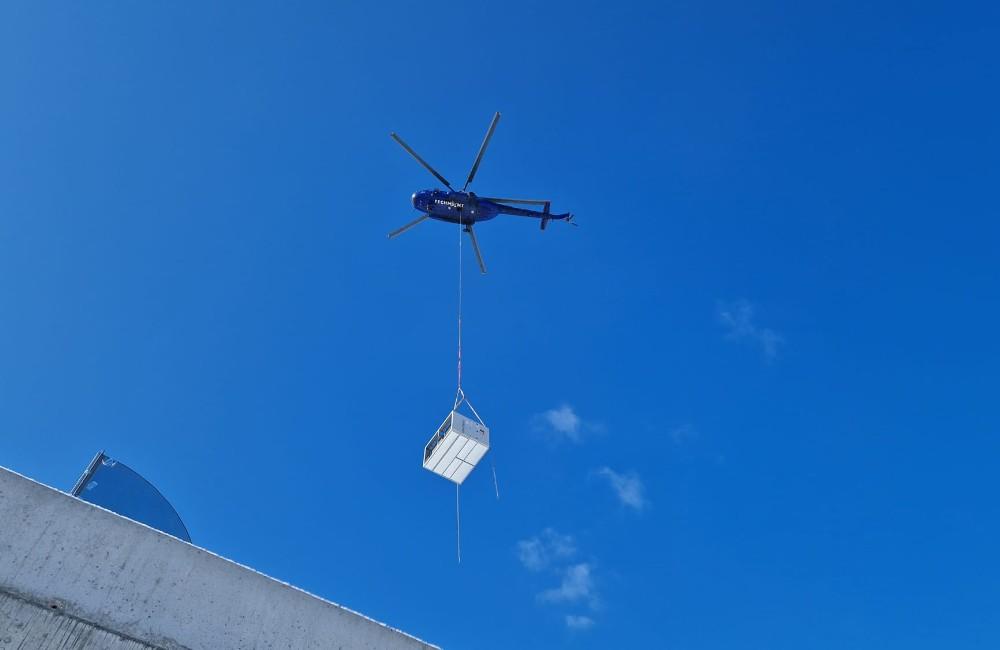 Foto: VIDEO: Ponad Vlčince lieta vrtuľník s ťažkým nákladom, nosí vzduchotechniku do novostavby na Obchodnej