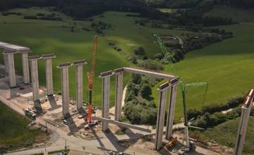 VIDEO: Na stavbe diaľničného mosta medzi obcami Višňové a Turie pokladajú nosníky vo výške 40 metrov