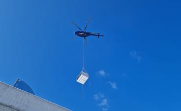 VIDEO: Ponad Vlčince lieta vrtuľník s ťažkým nákladom, nosí klimatizáciu do novostavby na Obchodnej