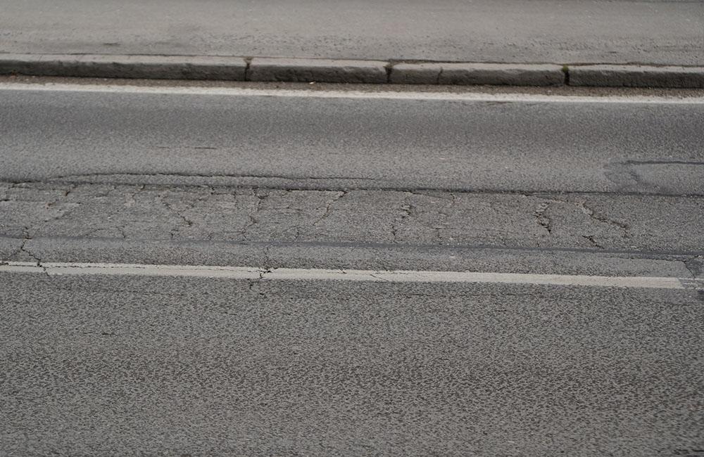 FOTO: Vozovka na ulici 1. mája v centre Žiliny sa rozpadáva, na ceste sú výtlky, koľaje a praskliny, foto 8